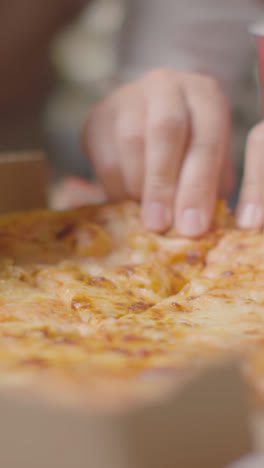 Vertical-Video-Close-Up-Of-Friends-At-Home-Sharing-Eating-Takeaway-Pizza-Delivery-1